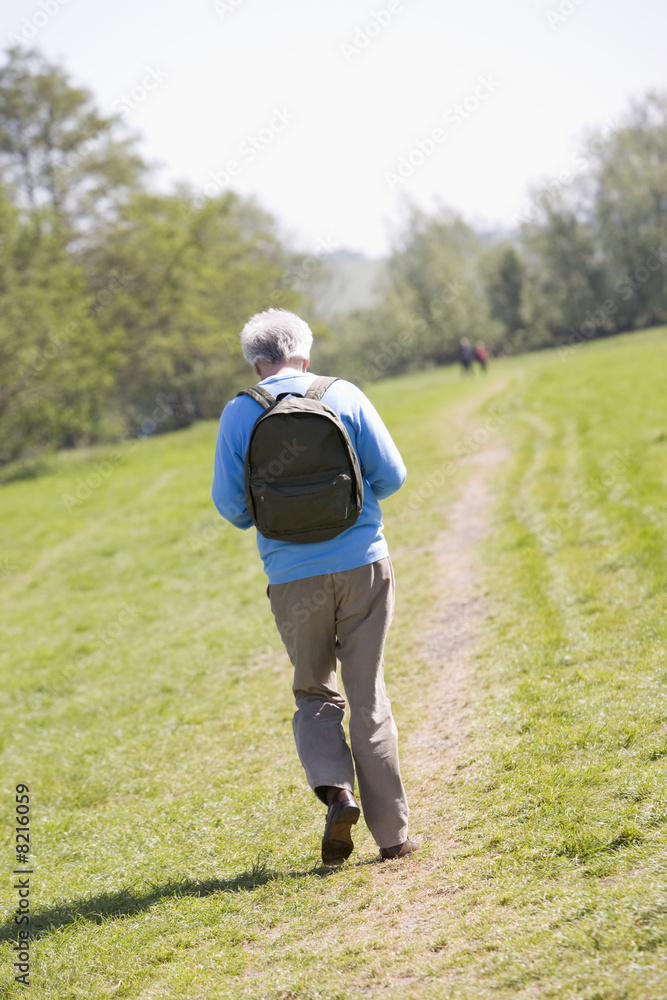 Fototapeta premium Man walking outdoors with people in background