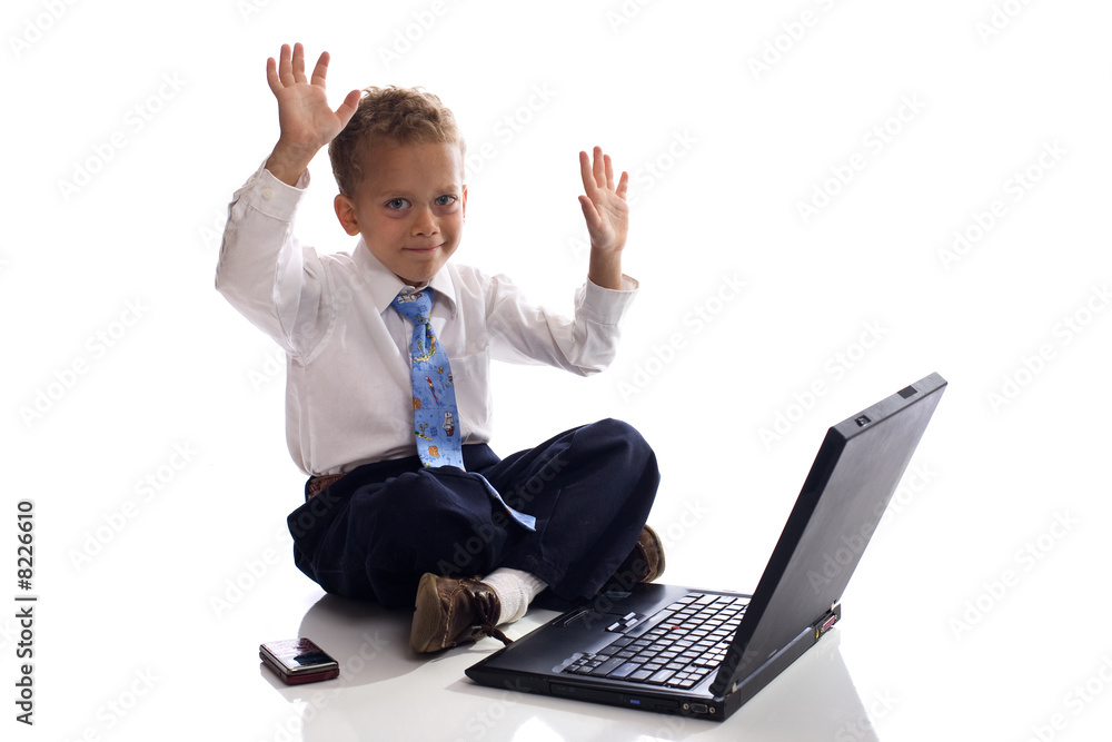 Young boy dressed as businessman works on his laptop computer - Young boy dressed as businessman works on his laptop computer -