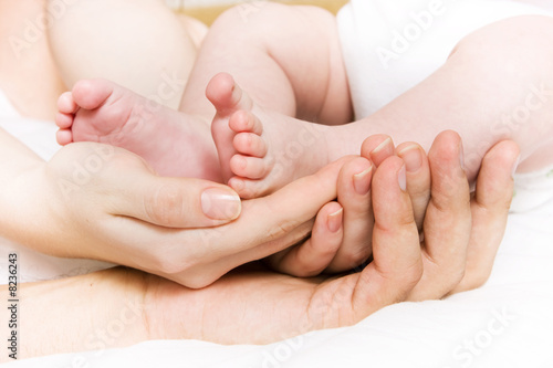 Baby foots in hands of parents © NiDerLander