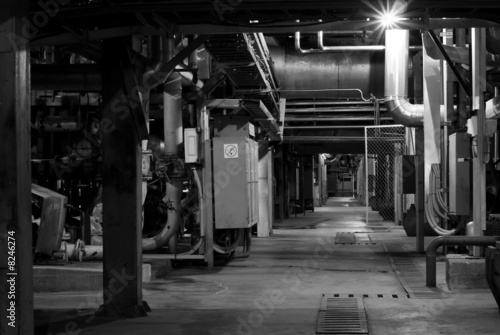 Machinery, pipes, and boilers at factory black and white
