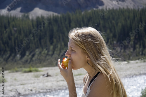 young woman biting into a nectarine
