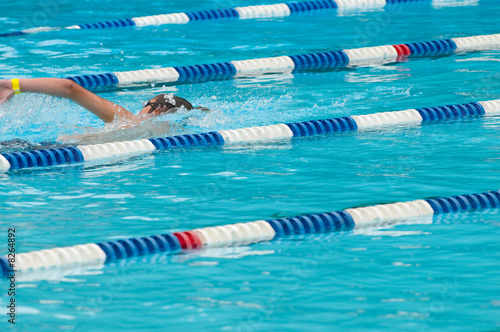 Non-identifiable swimmer in outdoor swimming pool