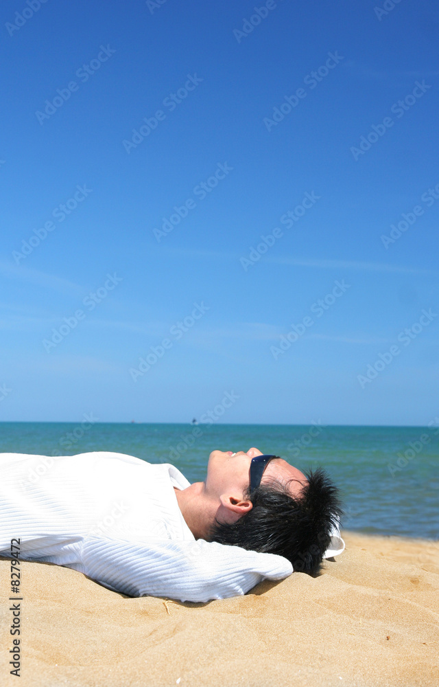 man lie down on tropical beach sand