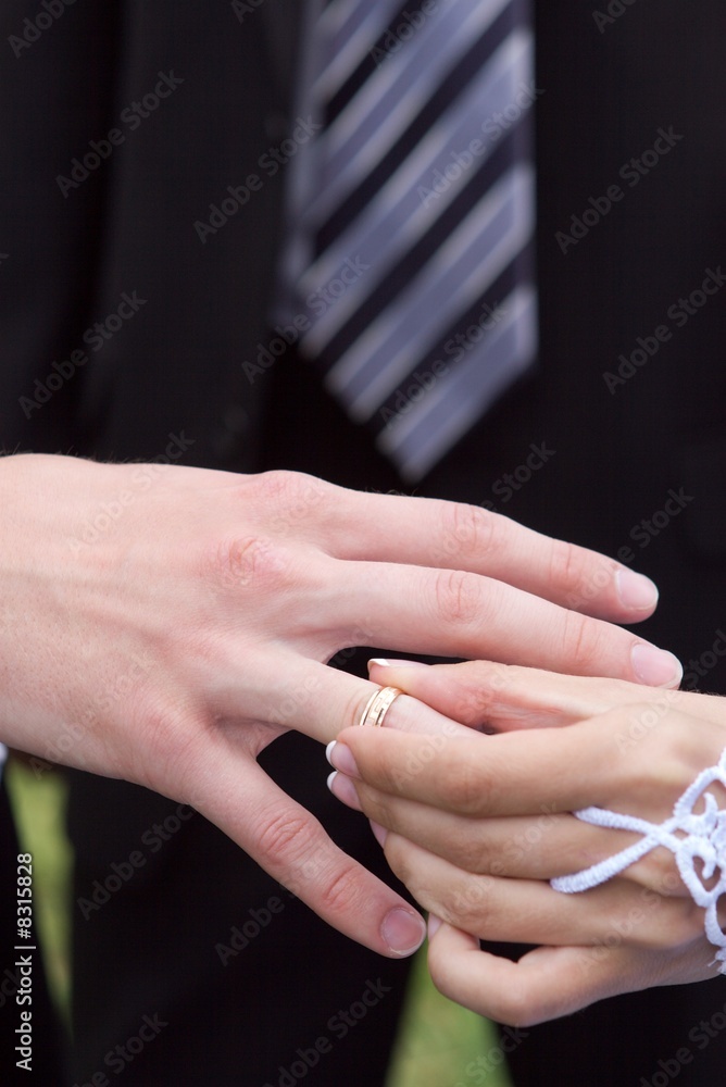 The bride puts on to the  groom a gold ring