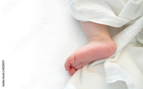 Baby foot over white sheet