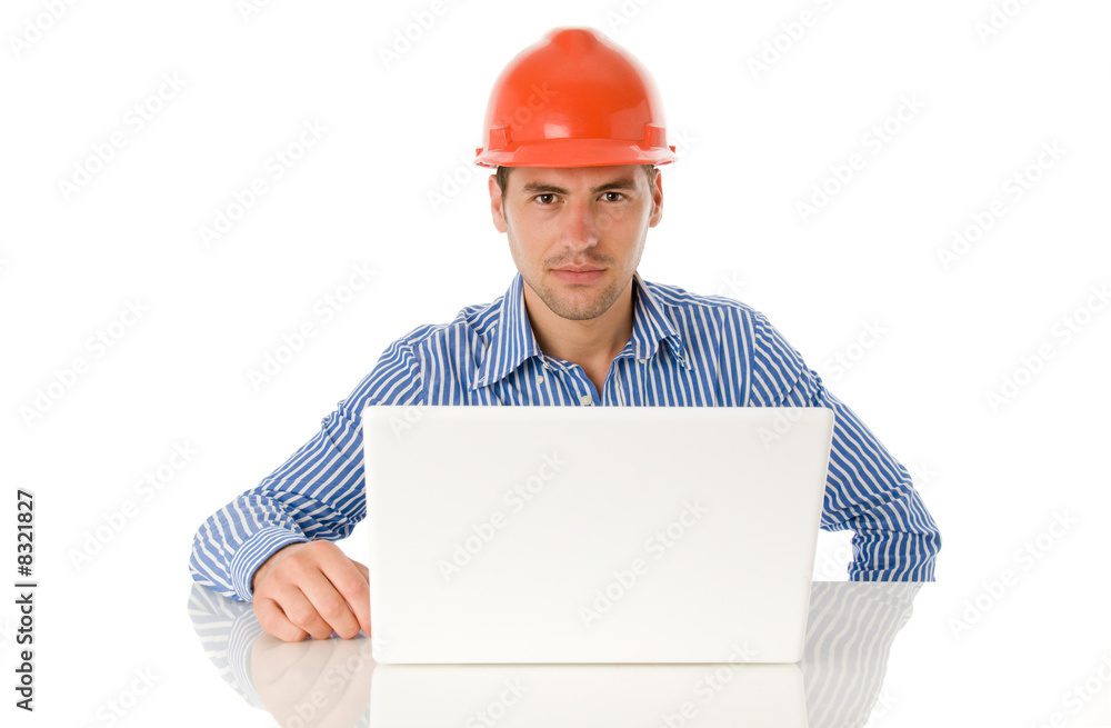 Architect sitting wearing the helmet and works with the laptop Architect sitting wearing the helmet and works with the laptop
