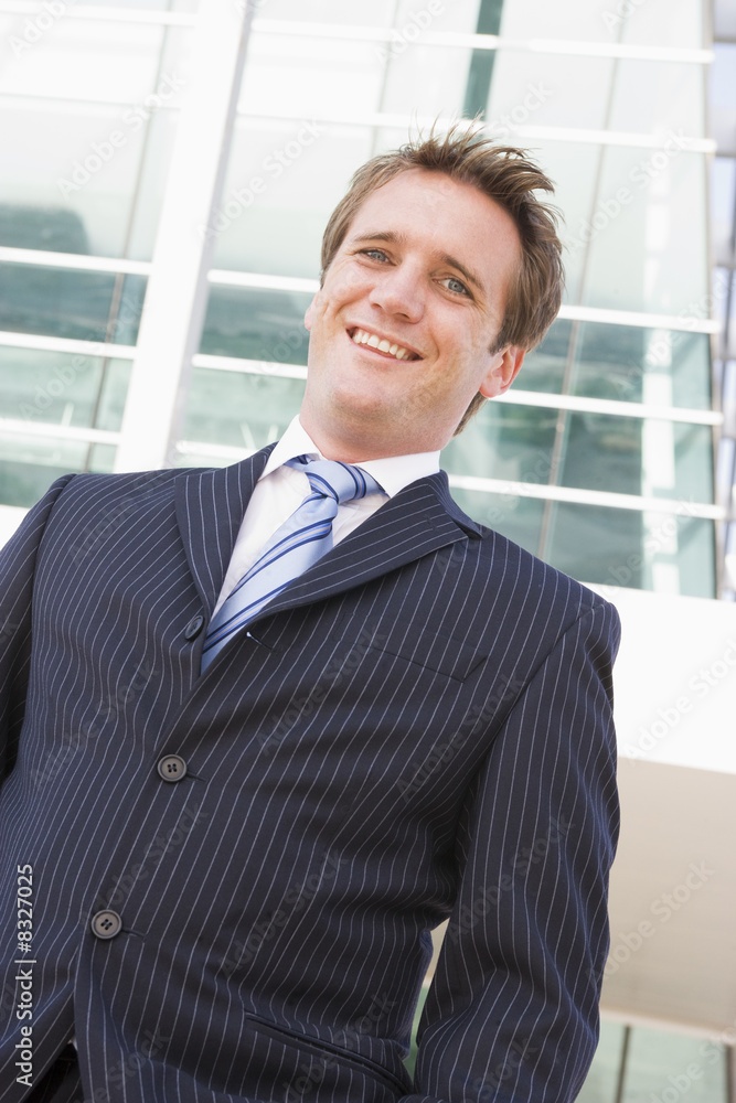 Businessman standing outdoors smiling Businessman standing outdoors smiling
