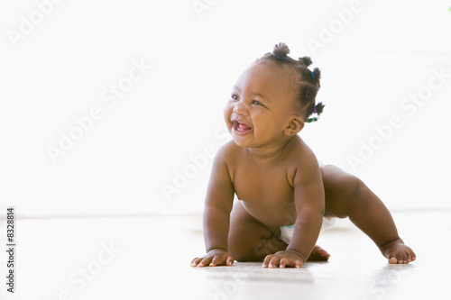 Baby crawling indoors smiling