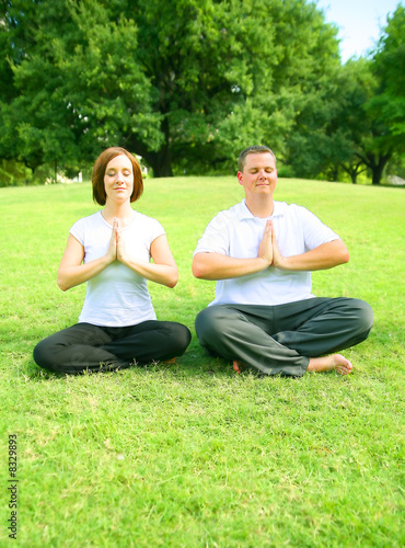 Couple Meditating In Park