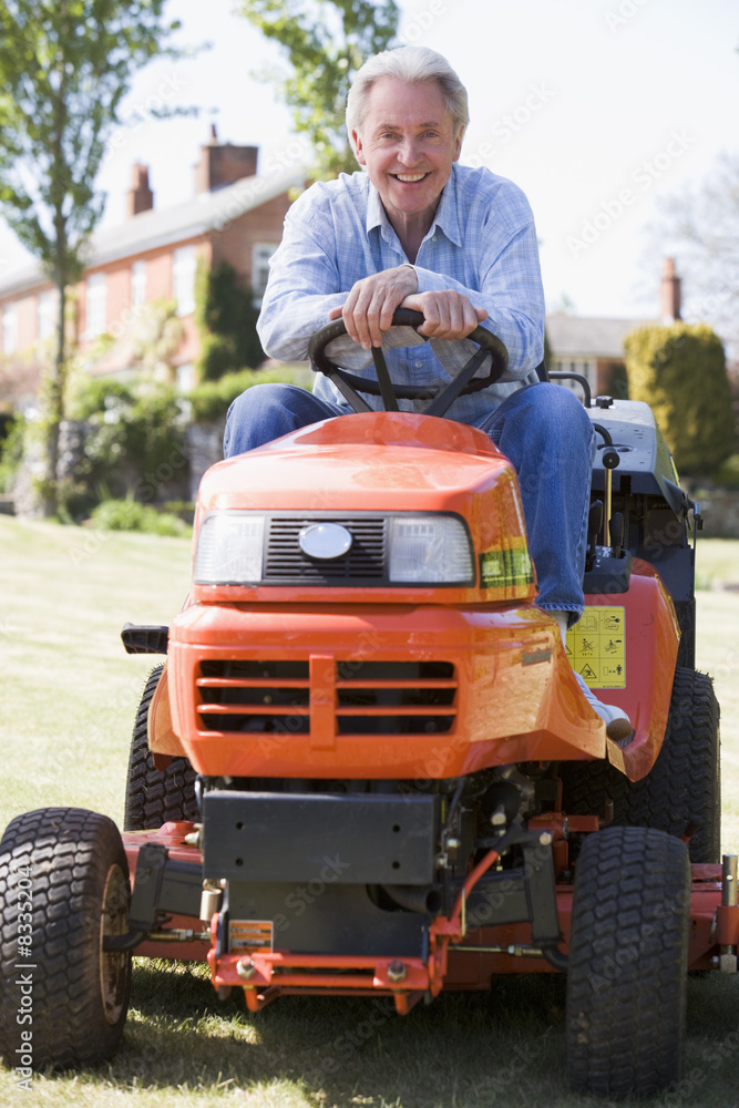 Man outdoors on lawnmower smiling Man outdoors on lawnmower smiling