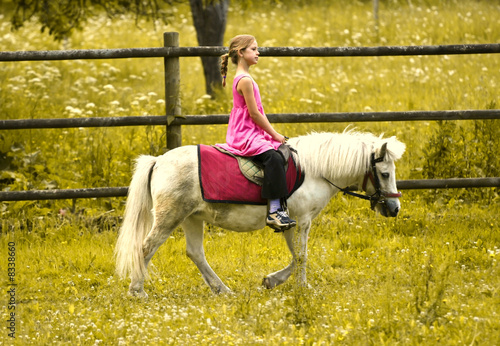 Young girl riding pony