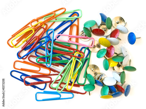Some multicolored pins and paper clips at the white table