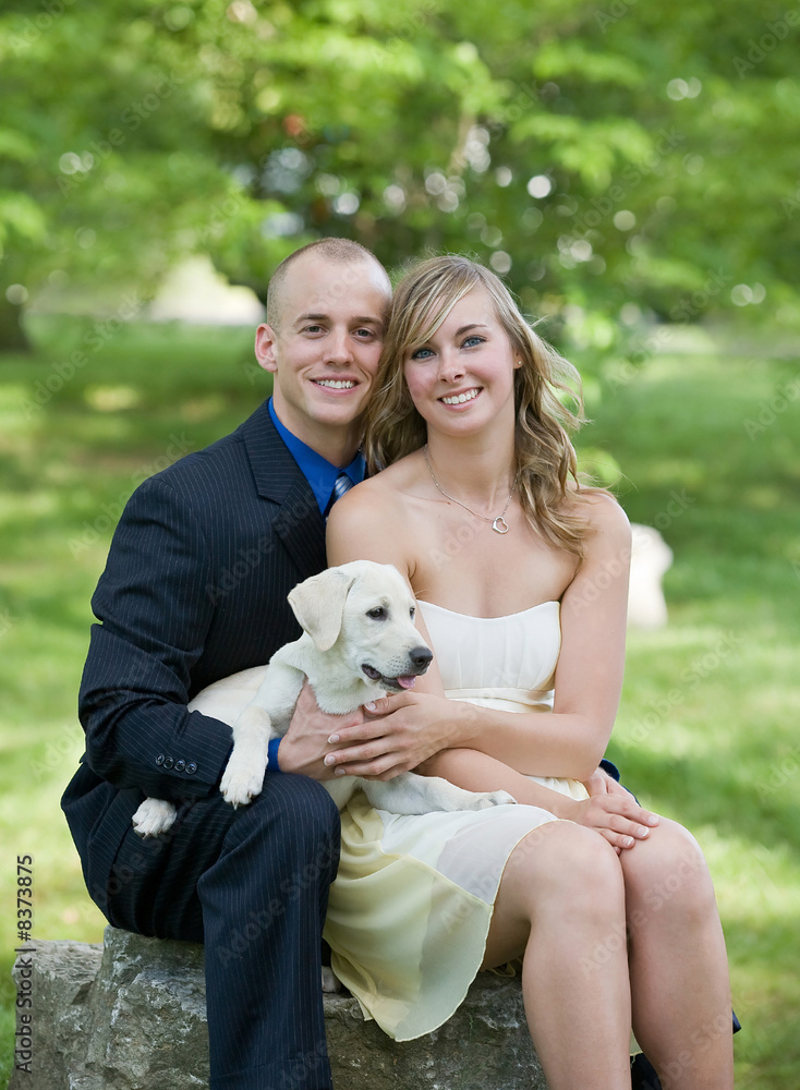 Fototapeta premium Couple Dressed Up With Their Puppy