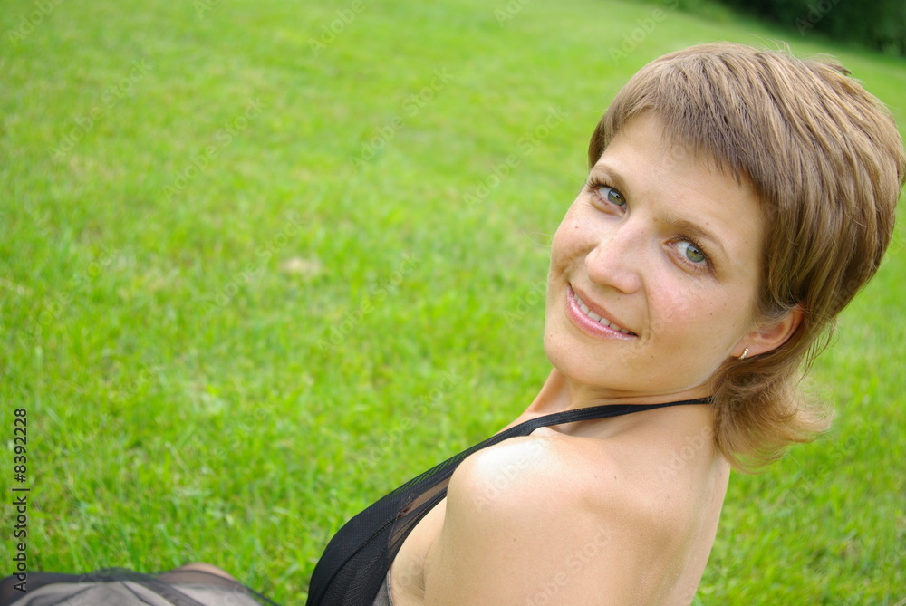 Attractive young woman against green grass Attractive young woman against green grass