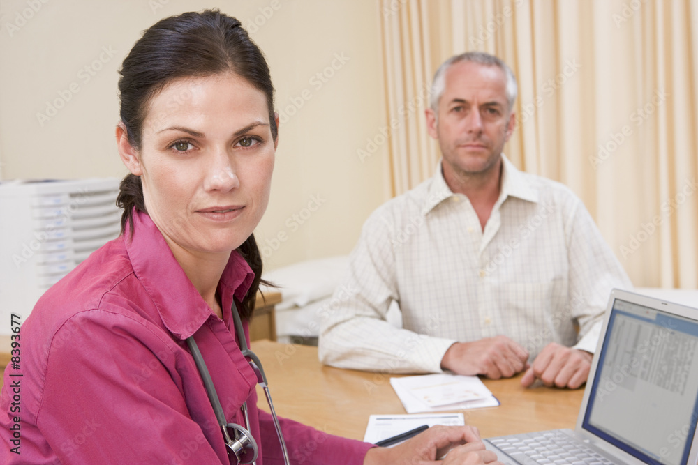 Fototapeta premium Doctor with laptop and man in doctor's office frowning
