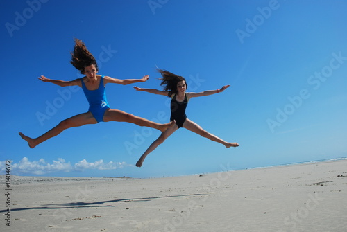 2 fillettes faisant le grand écart sur la plage