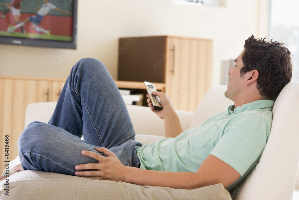 Obraz premium Man in living room watching television