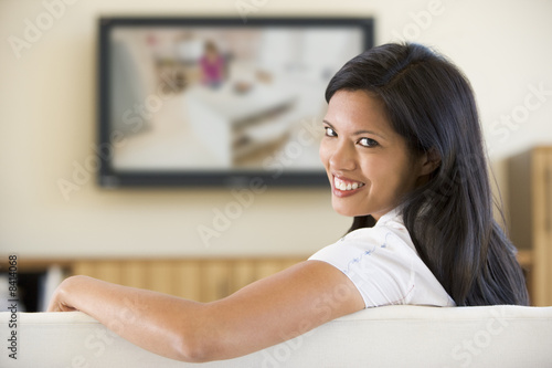Woman in living room watching television smiling Free Download Woman in living room watching television smiling - GFXLoad