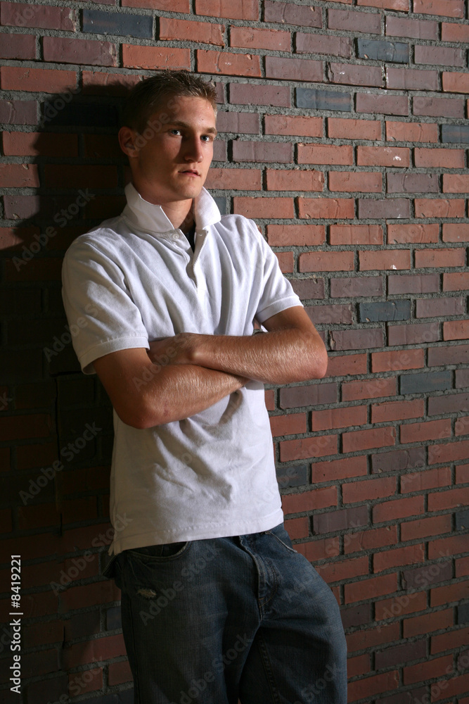 muscle man standing next to brick wall muscle man standing next to brick wall