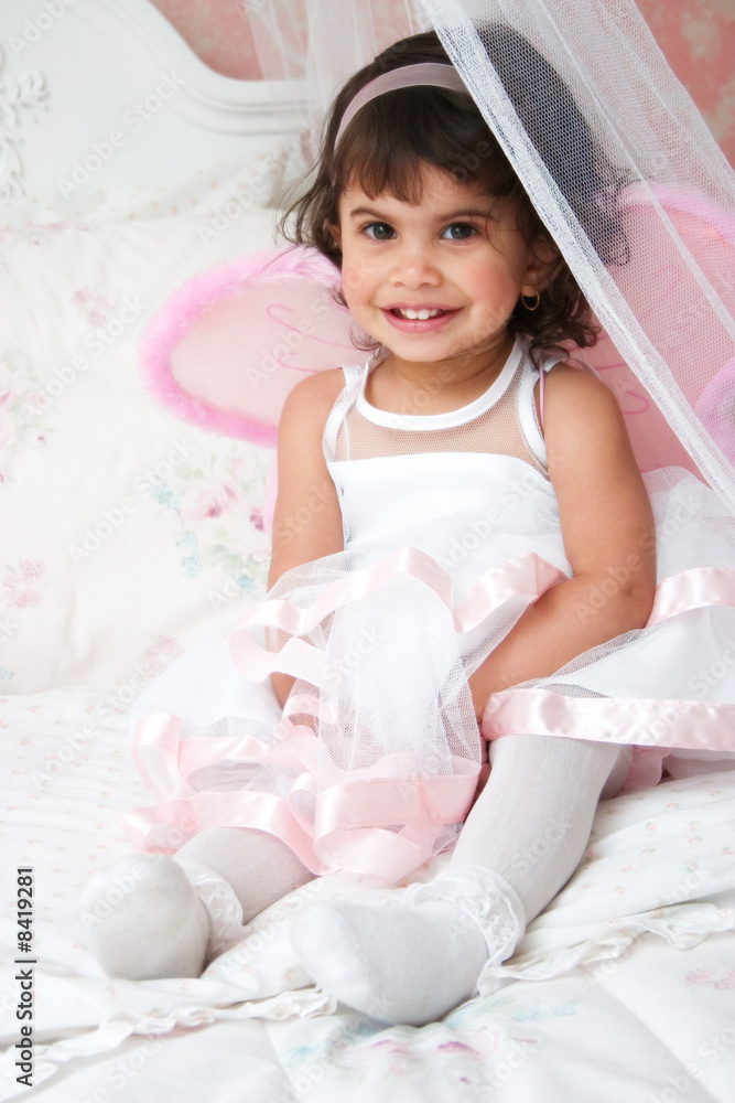 Little Hispanic Girl Smiling Wearing White Dress with Wings Little Hispanic Girl Smiling Wearing White Dress with Wings