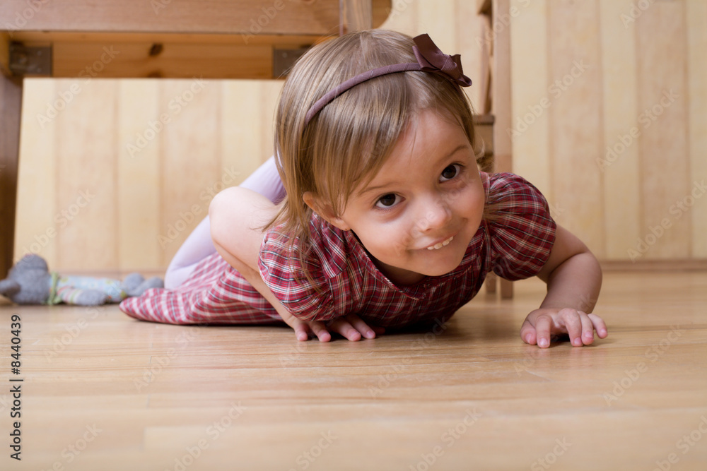 Happy little girl crawling on the hardwood floor Happy little girl crawling on the hardwood floor