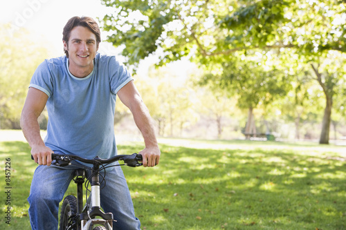 Man outdoors on bike smiling