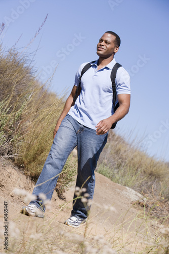 Man walking a trail in the countryside.