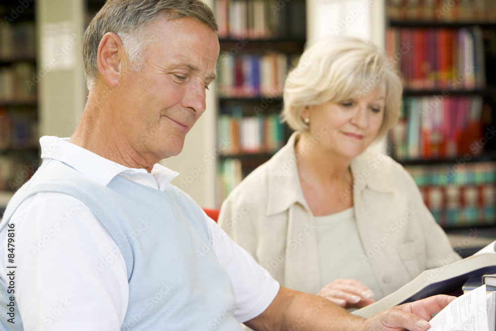 Adult students reading in a library Adult students reading in a library
