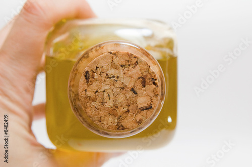 man keeps a bottle of olive oil. closed-up