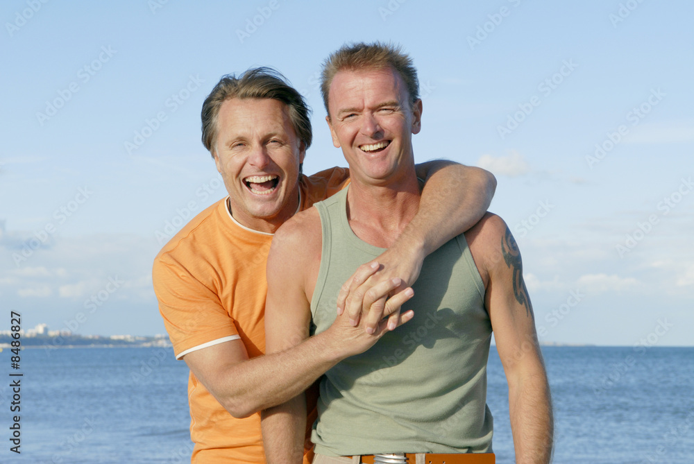 A gay couple having fun on the beach together. A gay couple having fun on the beach together.