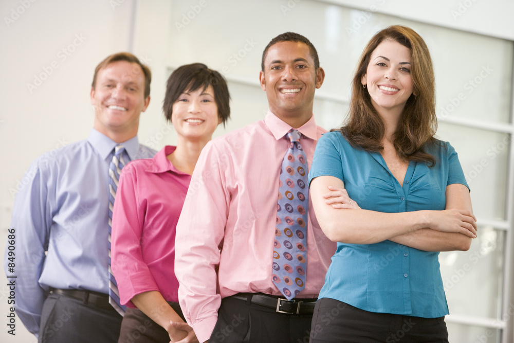 Business team standing indoors smiling Business team standing indoors smiling