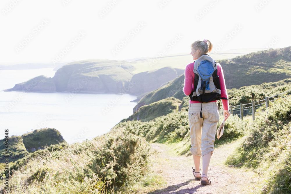 Woman walking on cliffside path