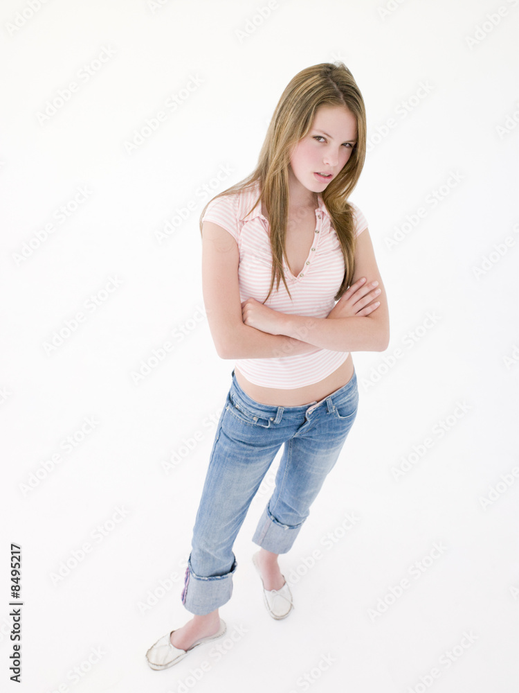Teenage girl with arms crossed frowning Teenage girl with arms crossed frowning