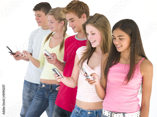 Row of five friends using cellular phones smiling photo