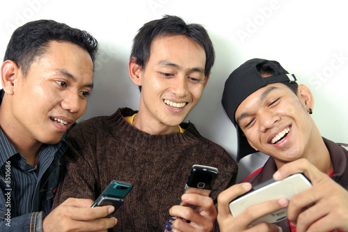 three man having fun on mobile device