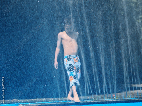 kind spielt mit dem wassersprenger photo