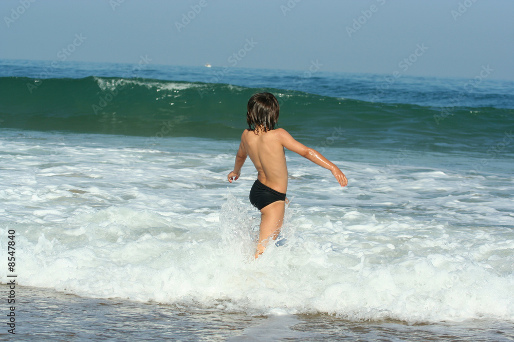 petit garçon entrain de jouer au bord de l'eau