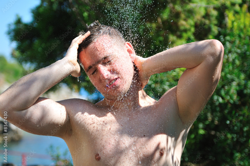young man relaxing under shower young man relaxing under shower