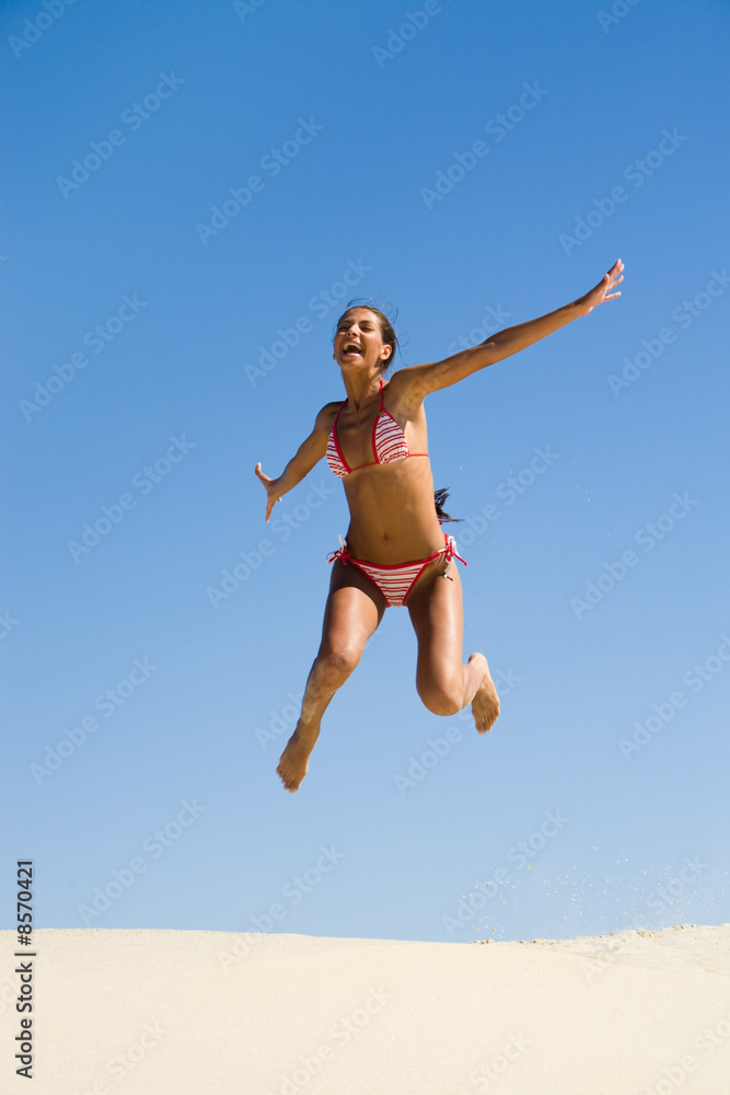 Portrait of joyful girl leaping on sandy beach Portrait of joyful girl leaping on sandy beach