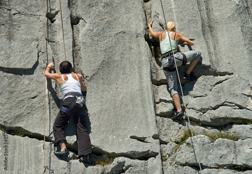 Two female rock climbers climbing limestone in Switzerland