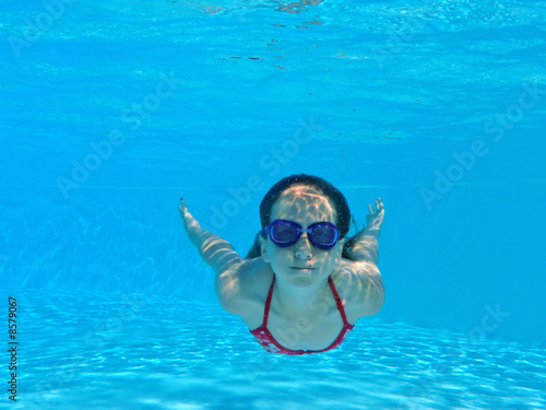 Enfant nage sous l'eau avec lunette