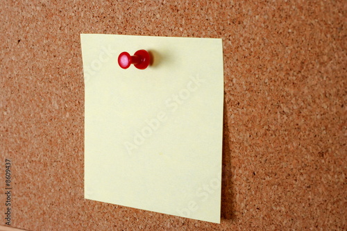 yellow note paper with tack on cork