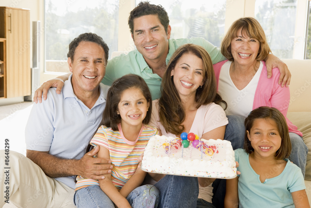 Fototapeta premium Family in living room with cake smiling
