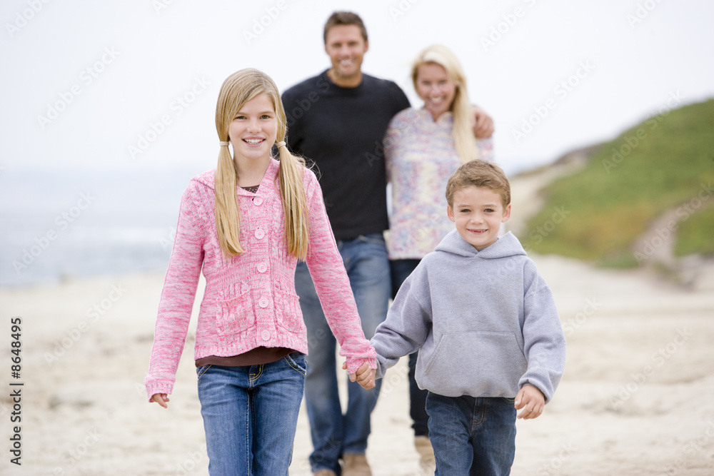 Family walking at beach holding hands smiling Family walking at beach holding hands smiling