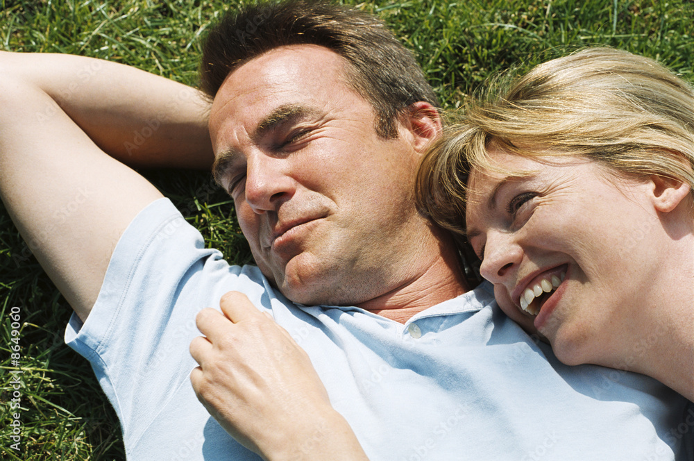 Couple lying outdoors smiling Couple lying outdoors smiling