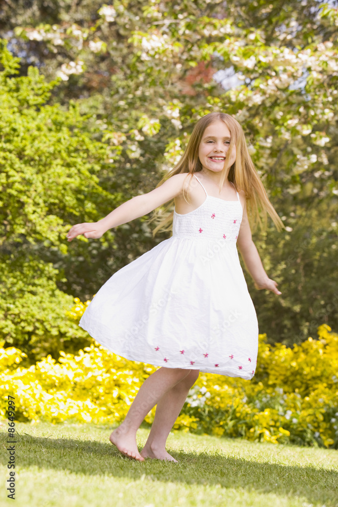 Young girl standing outdoors smiling