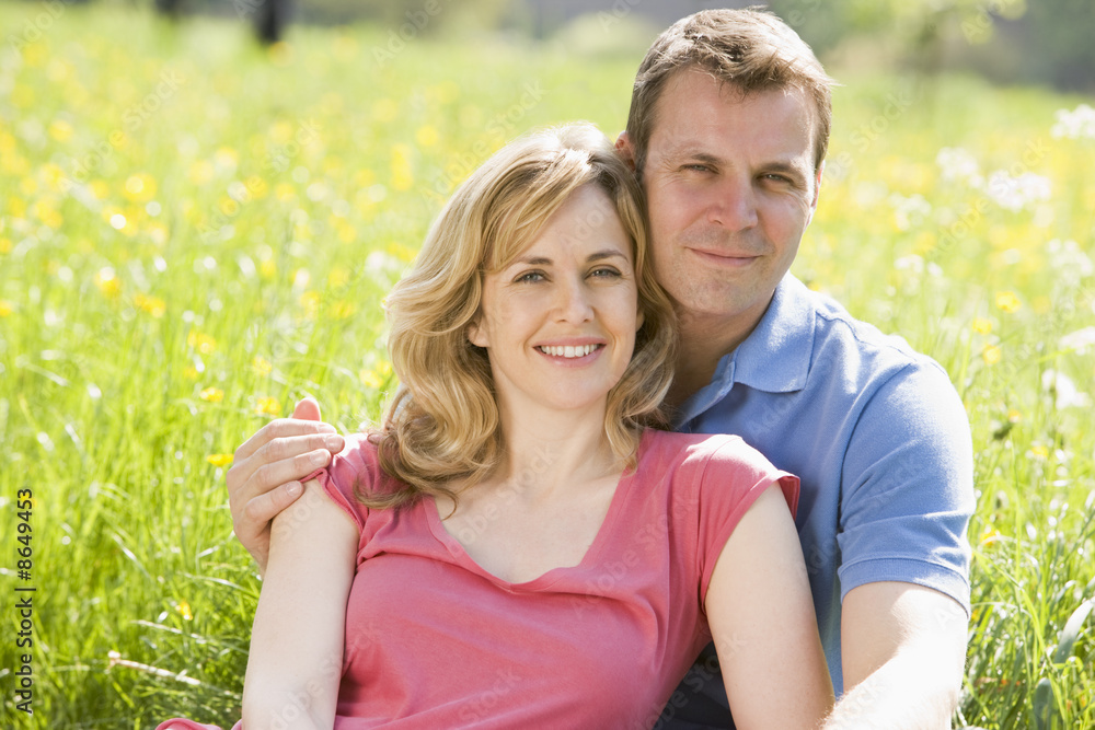 Couple sitting outdoors smiling