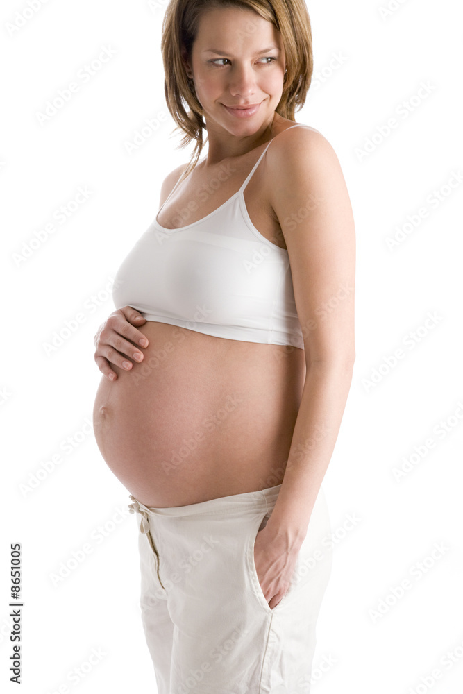 Pregnant woman holding exposed belly smiling Pregnant woman holding exposed belly smiling