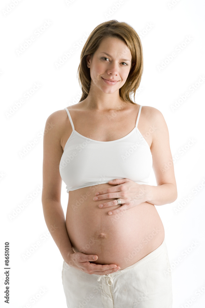 Pregnant woman holding exposed belly smiling Pregnant woman holding exposed belly smiling