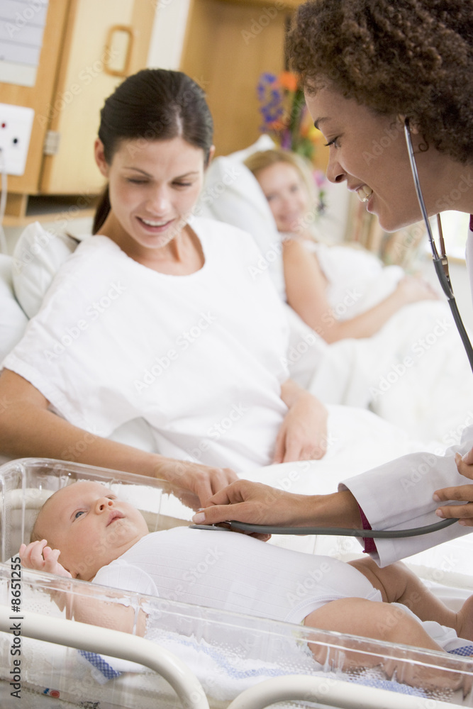 Doctor checking baby's heartbeat with new mother watching and sm Doctor checking baby's heartbeat with new mother watching and sm